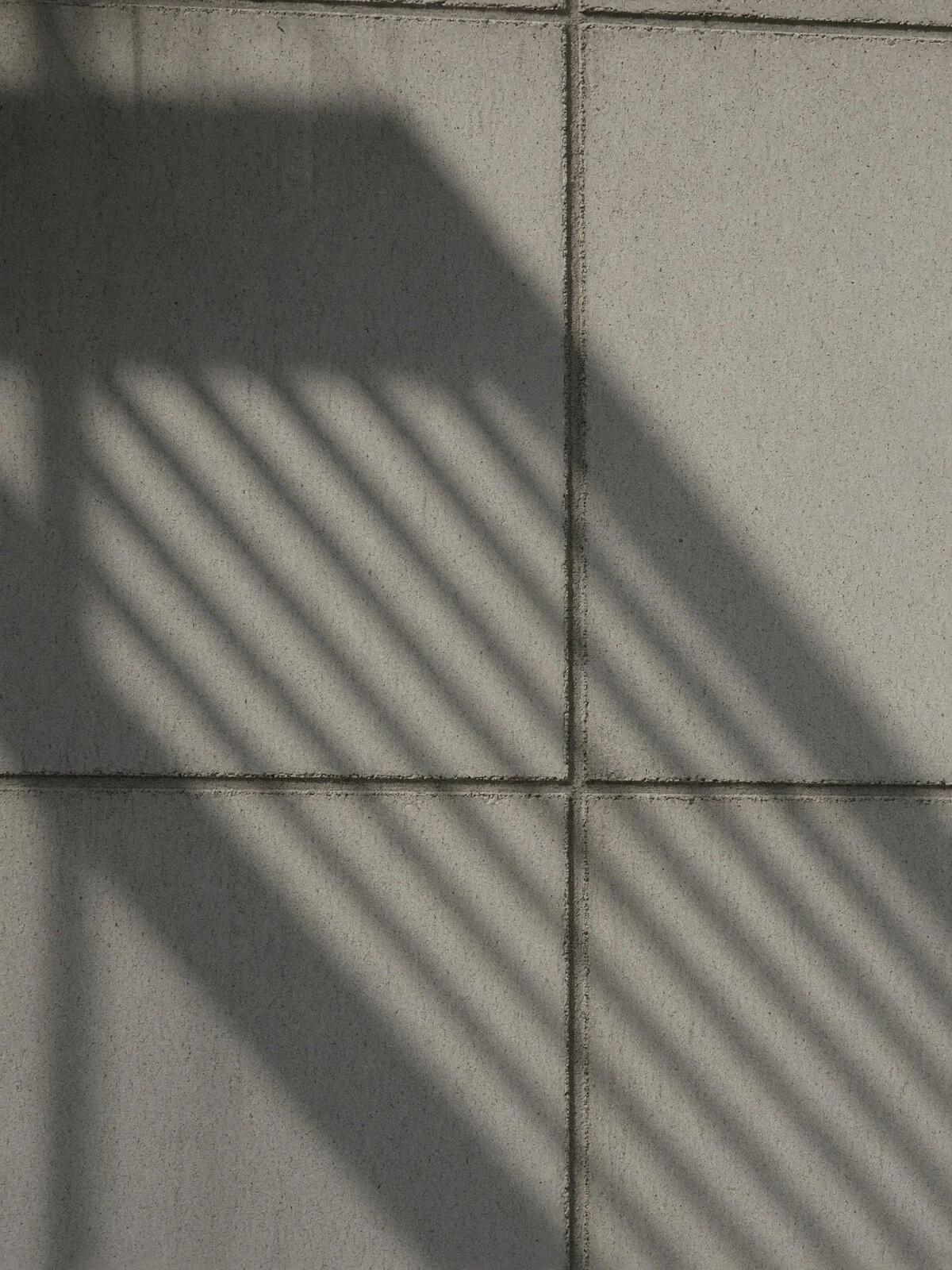 Lines of sunlight and shadow across an architectural facade.